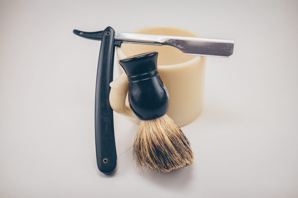 Picture of straight razor, with badger hair brush and cup.